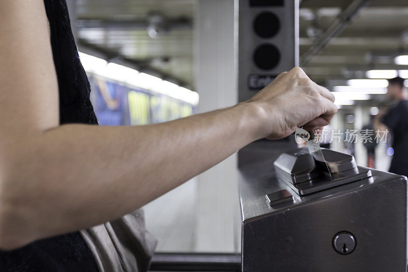 女人在地铁车站用门禁卡举手