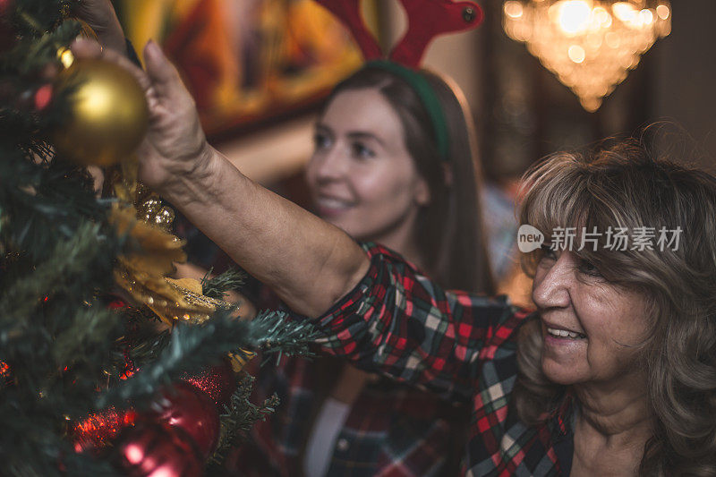 奶奶在帮助下装饰圣诞树