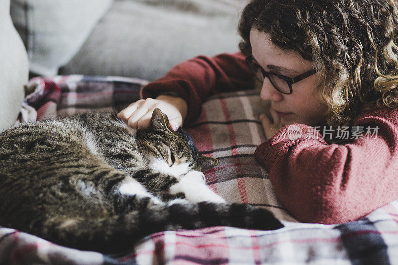 一个美丽的女孩看着她的猫睡觉