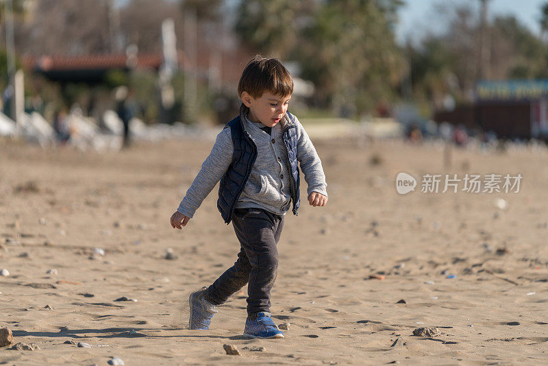 小男孩在海滩上跑步