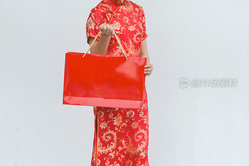 亚洲女人提着购物袋，女人穿旗袍，过年
