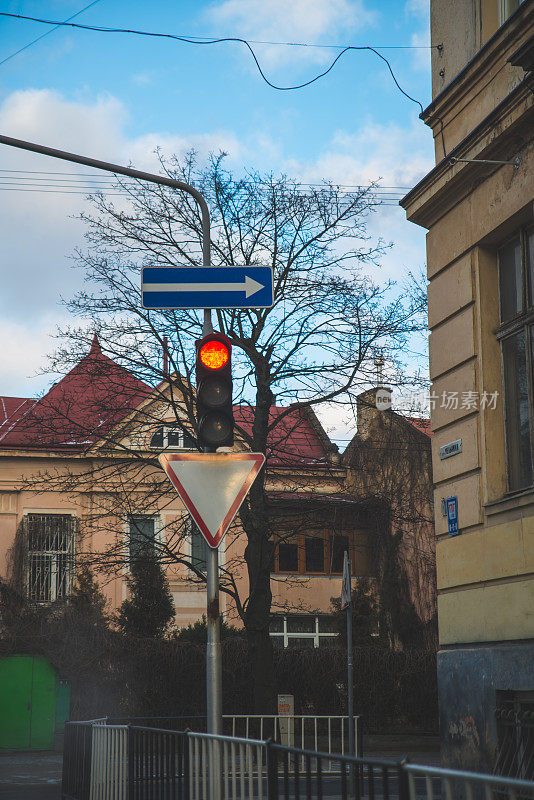 城市街道上的红色交通灯，蓝天和云彩的背景