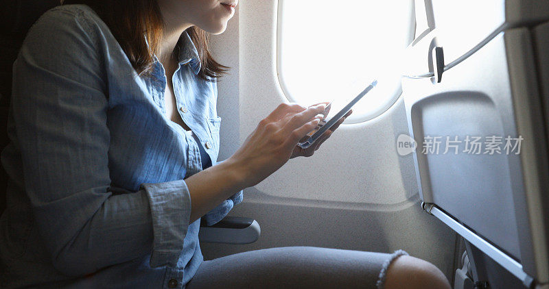 飞机上的年轻女子在起飞前发短信