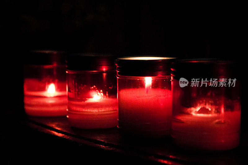 天主教教堂内红色祈祷蜡烛排成一排燃烧
