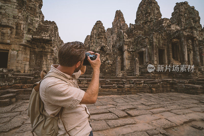 男游客拍摄古庙和古庙雕刻