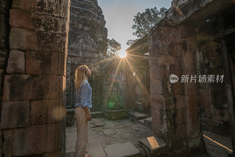 女游客漫游在古老的寺庙日落享受发现和旅游在亚洲，柬埔寨吴哥窟