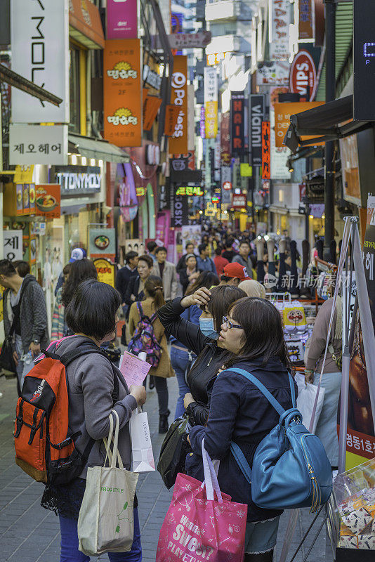 在韩国首尔市中心拥挤的明洞商业街购物的人们
