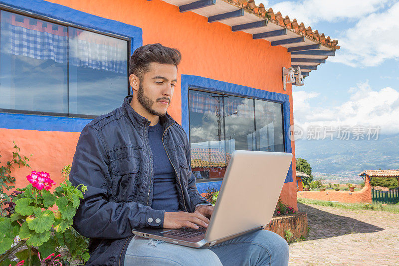 与科技一起在户外工作――年轻人坐在户外使用笔记本电脑