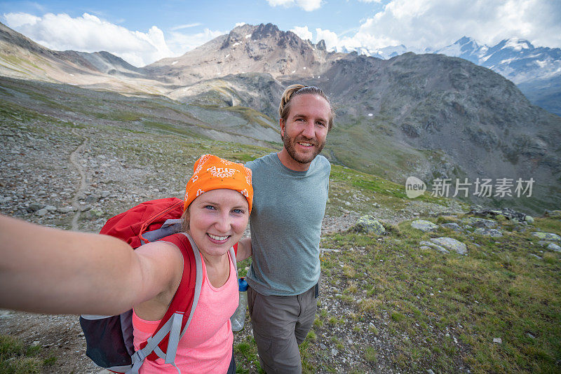 年轻夫妇在山间远足时拍自拍照