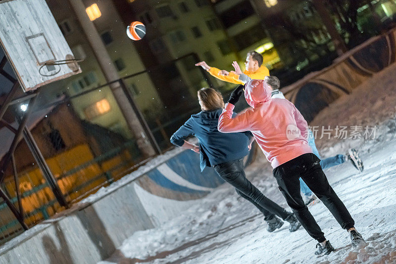 一队年轻人在白雪覆盖的操场上玩街球
