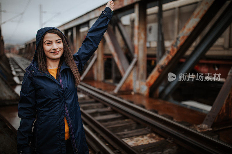 下雨天，年轻女子在铁路桥上