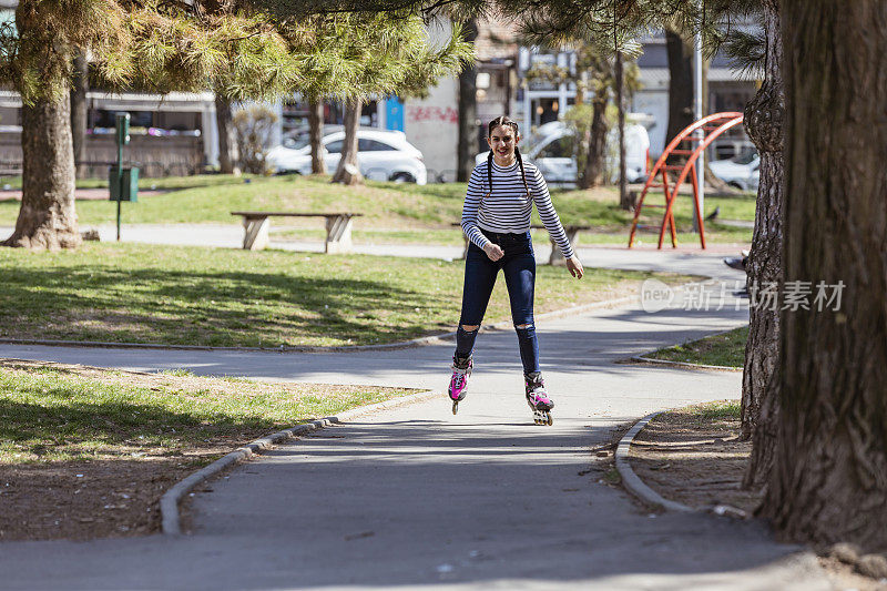 可爱的少女在公共公园溜冰
