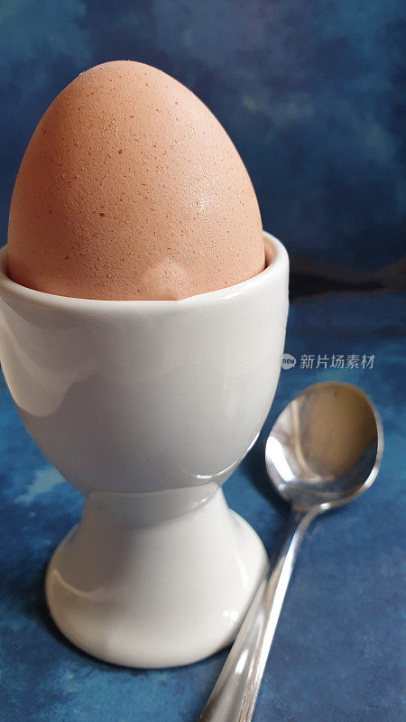 用勺子把鸡蛋放在蛋杯里