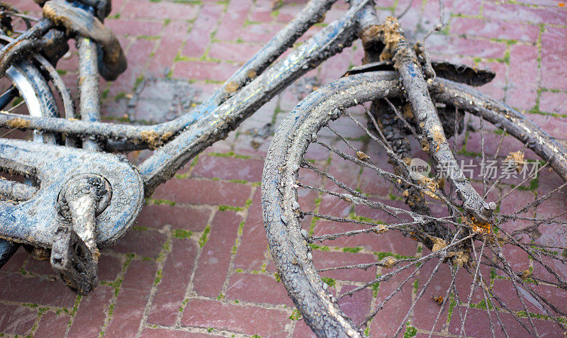 荷兰:一辆锈迹斑斑的旧自行车被扔在砖砌的人行道上