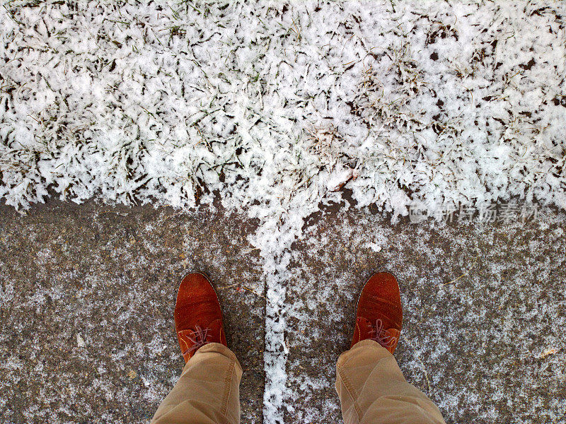 脚踩在雪地里的瓷砖上。