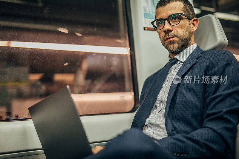 一个商人在火车上用笔记本电脑工作