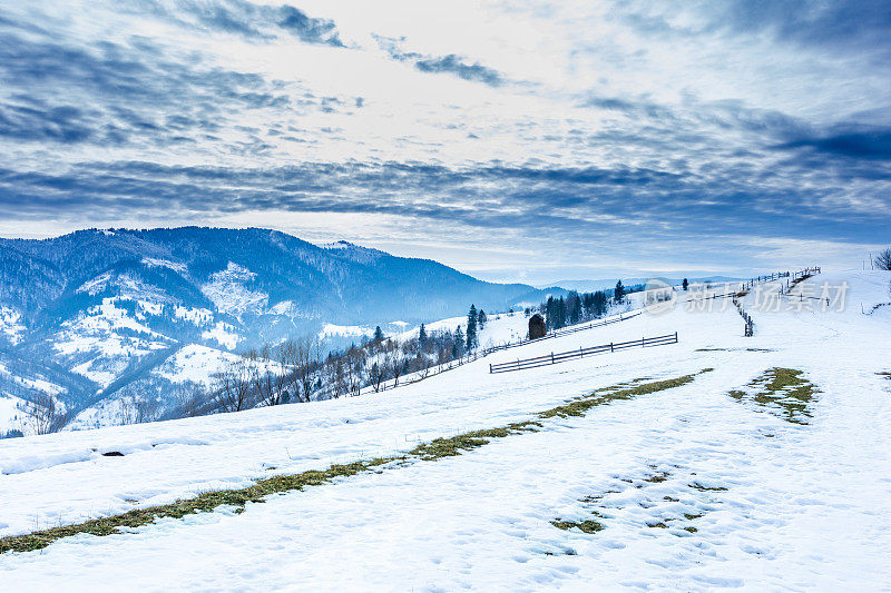 山峰上的雪被风吹走了。冬天的风景。天很冷，下着雪。