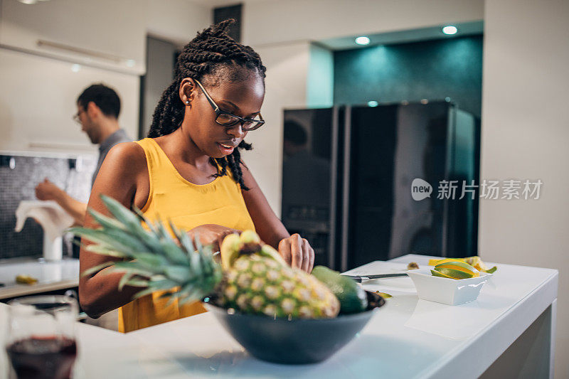 年轻夫妇在厨房里准备水果沙拉