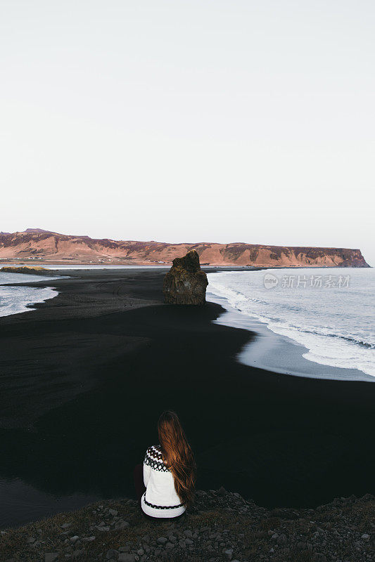 女人在享受冰岛美丽的黑色沙滩的景色