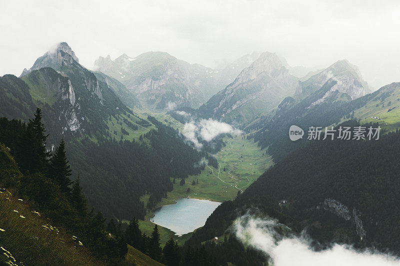 在瑞士阿尔卑斯山的夏季雨天，绿松石湖和山被雾覆盖的戏剧性景色