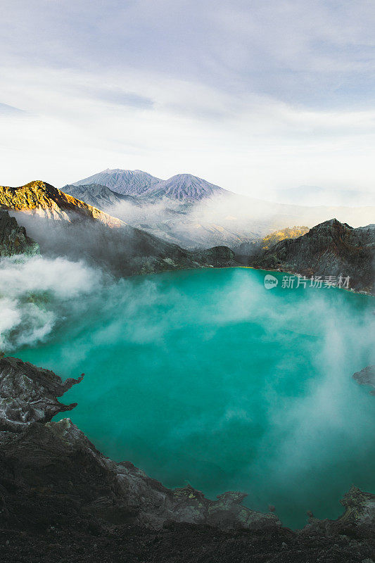 印度尼西亚东爪哇的伊真火山火山口的绿松石色湖泊，山脉和硫磺蒸汽的戏剧性景色