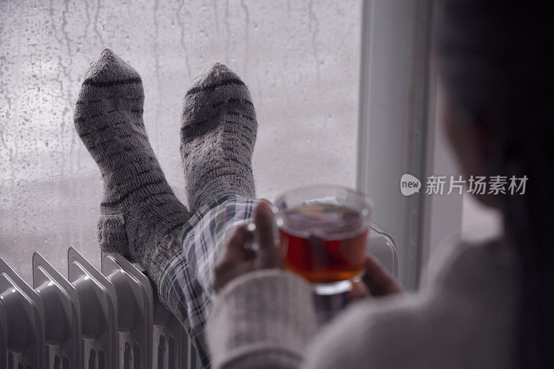 后面是一个女人在阴冷潮湿的天气在家喝茶的画面。