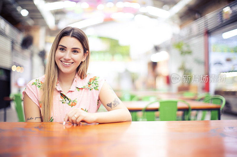 一名年轻女子坐在咖啡店打手势的肖像