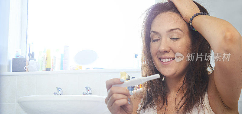 浴室里怀孕测试呈阳性的快乐女人