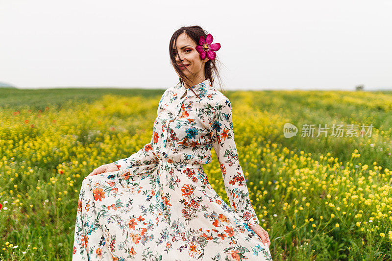 头发上戴着花的女人正在花圃里享受阳光