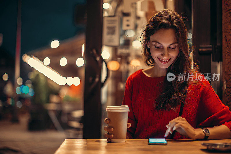 女人在咖啡馆喝咖啡和使用智能手机