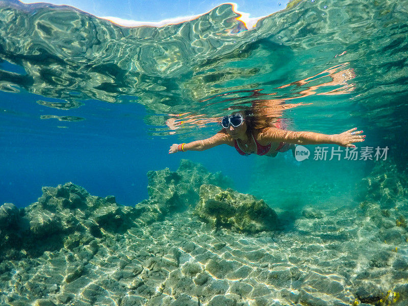 女人漂浮在干净的大海里。