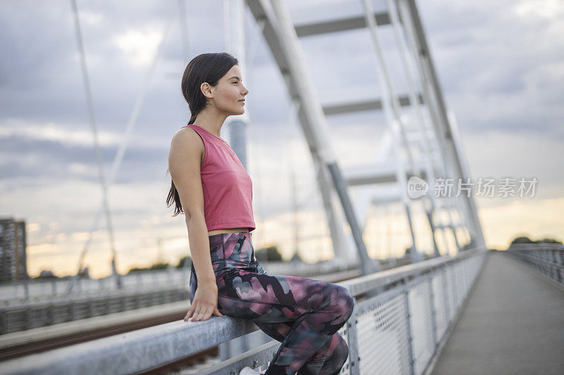 快乐的运动女人在户外慢跑后休息