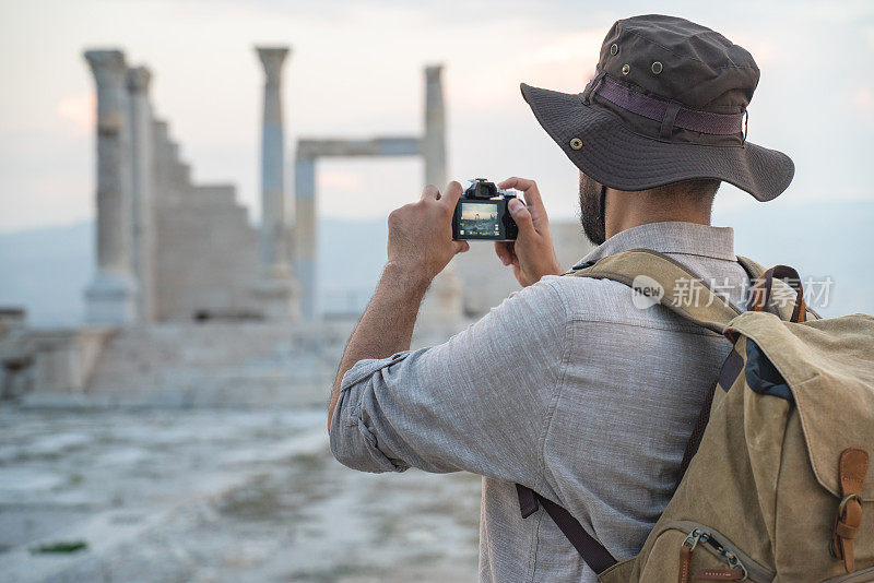 一名旅游摄影师正在帕慕克勒河畔的老底嘉遗址拍摄照片