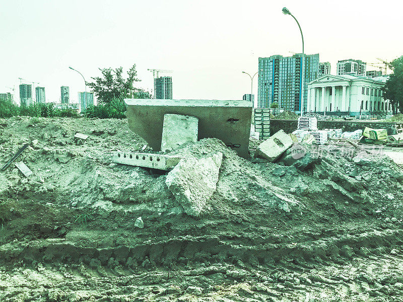 建筑景观。沙子上散落着建筑材料、混凝土和金属框架。笨重的垃圾，扔在地上。生态关闭，土地污染