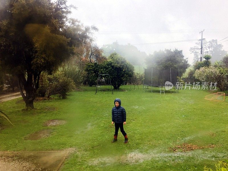 孩子在花园里的雨中玩耍