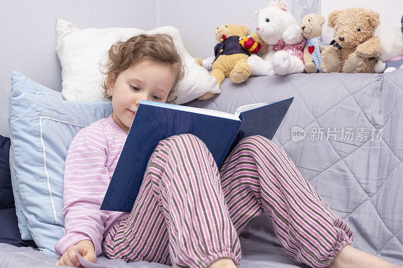 小女孩，白人5岁，读一本大精装书。