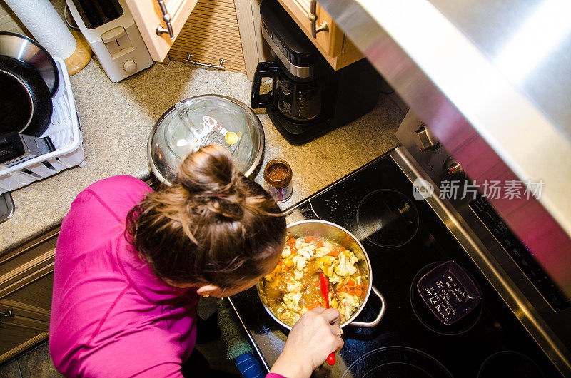 女人在平底锅里拌蔬菜