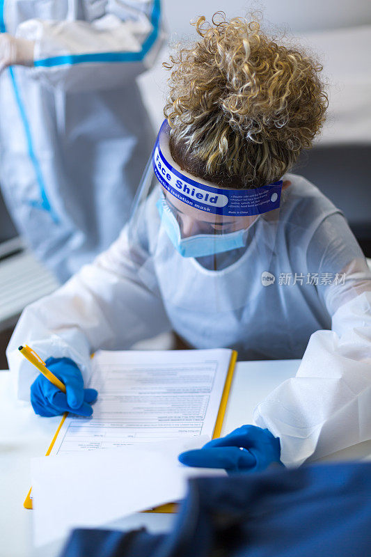 戴蓝手套的医护人员在疫苗接种中心进行冠状病毒免疫接种