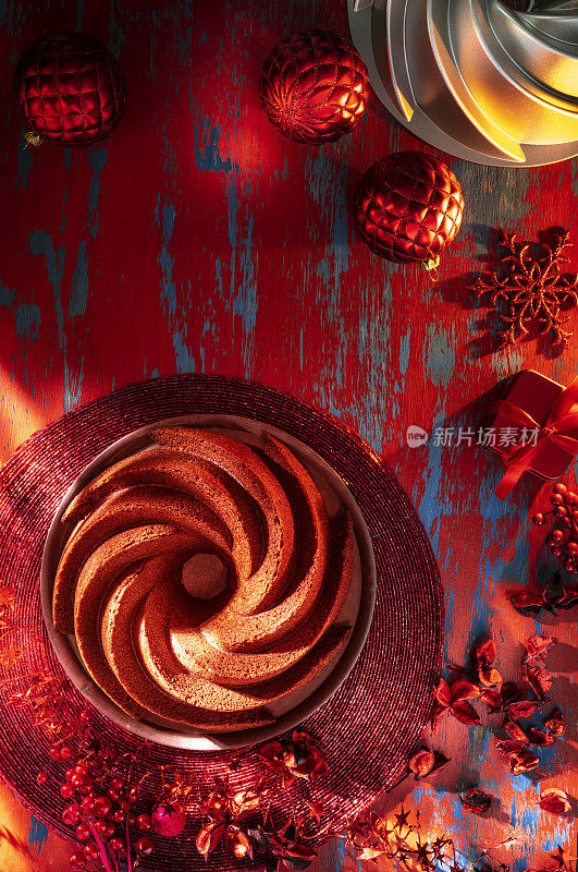 红色天鹅绒蛋糕作为Bundt蛋糕形状在圣诞节红色装饰背景