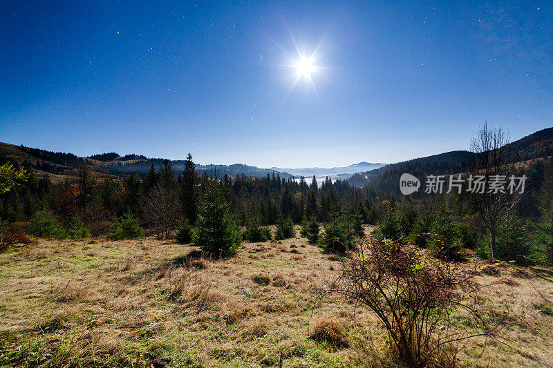 乌克兰山区的夜晚。月亮和星星与山的轮廓在月亮和星星在黑暗的天空。