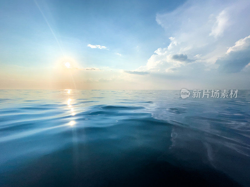 湛蓝平静的海面上鲜有涟漪，还有太阳和天空。