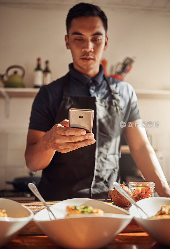 一名年轻男子用智能手机拍下自己在家准备的健康美食