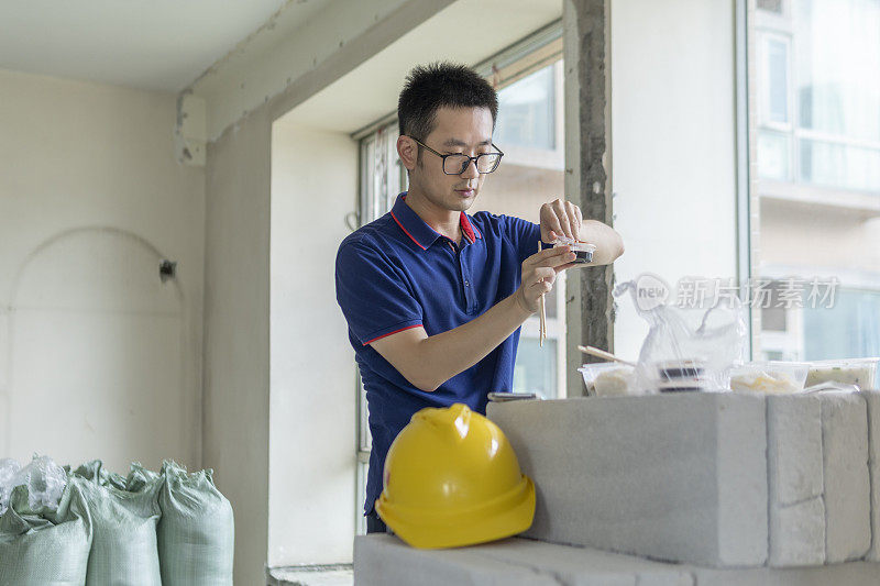 亚洲男工程师在装修工地吃外卖