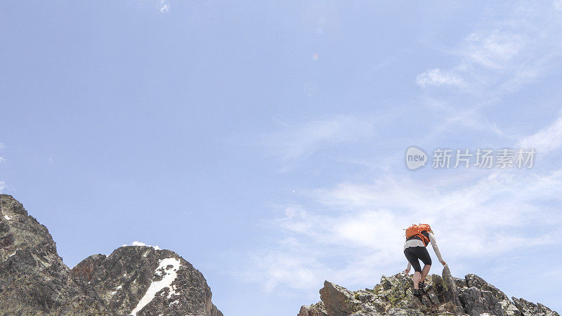 女登山运动员爬上阳光山岭