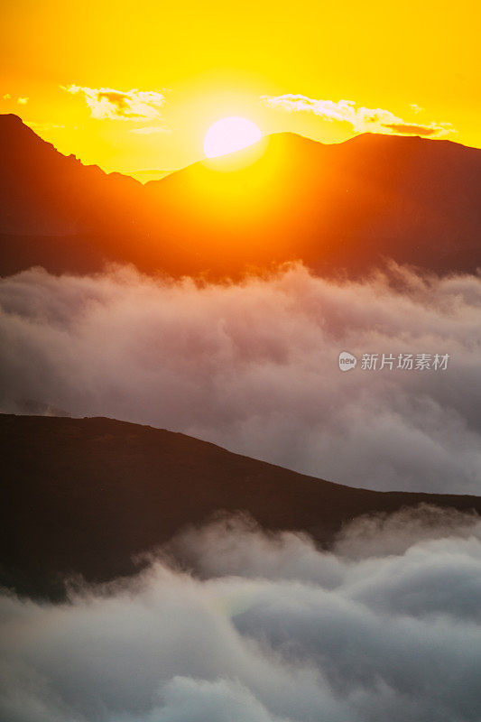 塔特拉山脉和黄色日落的秋景。云朵飘浮于山峰之上