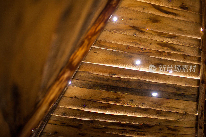 一所房子的木屋顶上有小孔，光线可以透过这些小孔照射进来