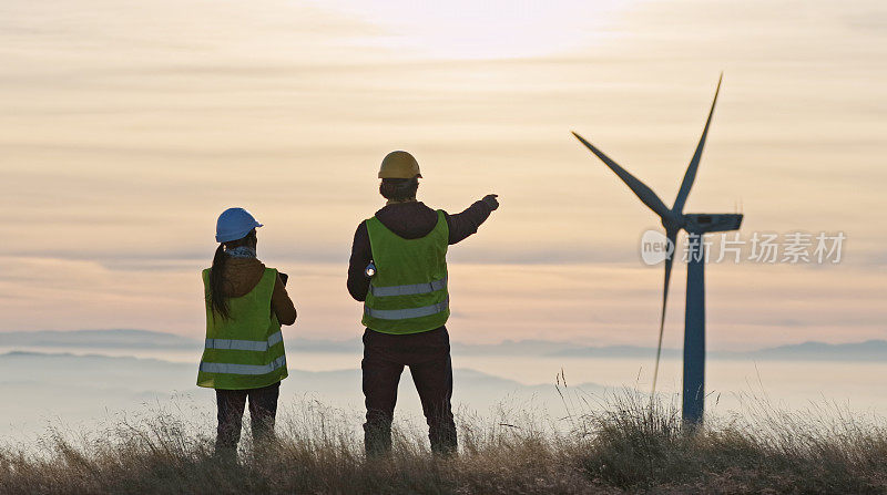 黄昏时分，风能工程师在风电场工作。可再生能源系统。碳中和和可持续能源。