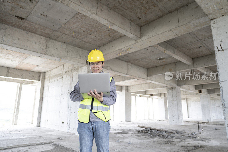 一个亚洲男性工程师在一个未完工的建筑工地