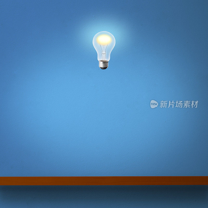 发光的灯泡漂浮在木制架子上，靠在蓝色的混凝土墙上