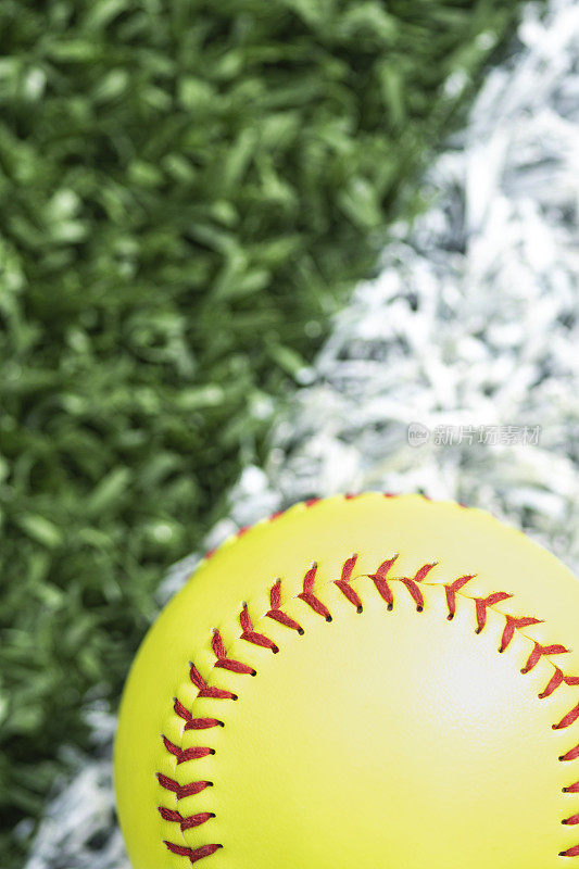 垒球:放在白底线草皮上的垒球